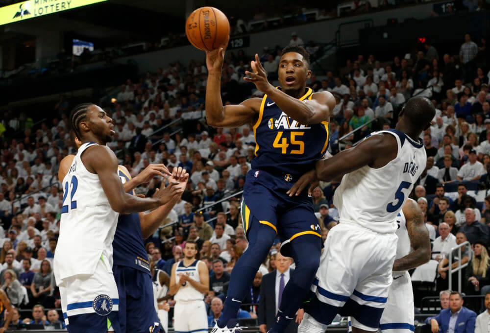 Utah Jazz's Donovan Mitchell, center, passes between Minnesota Timberwolves' Andrew Wiggins, left, and Gorgui Dieng, right, of Senegal, during the first half of an NBA basketball game Friday, Oct. 20, 2017, in Minneapolis. AP Photo/Jim Mone)